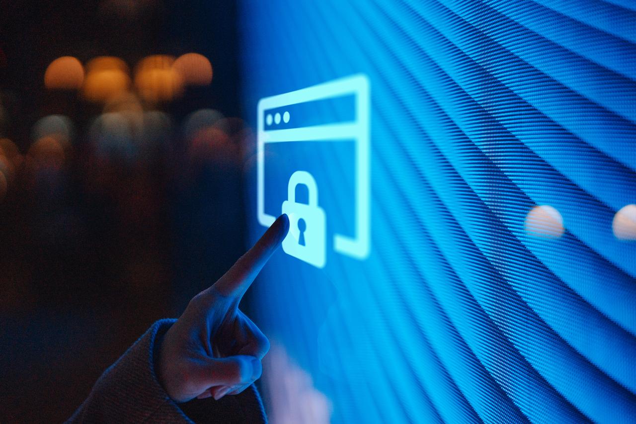 Close-up of a hand pointing to a padlock on an illuminated screen